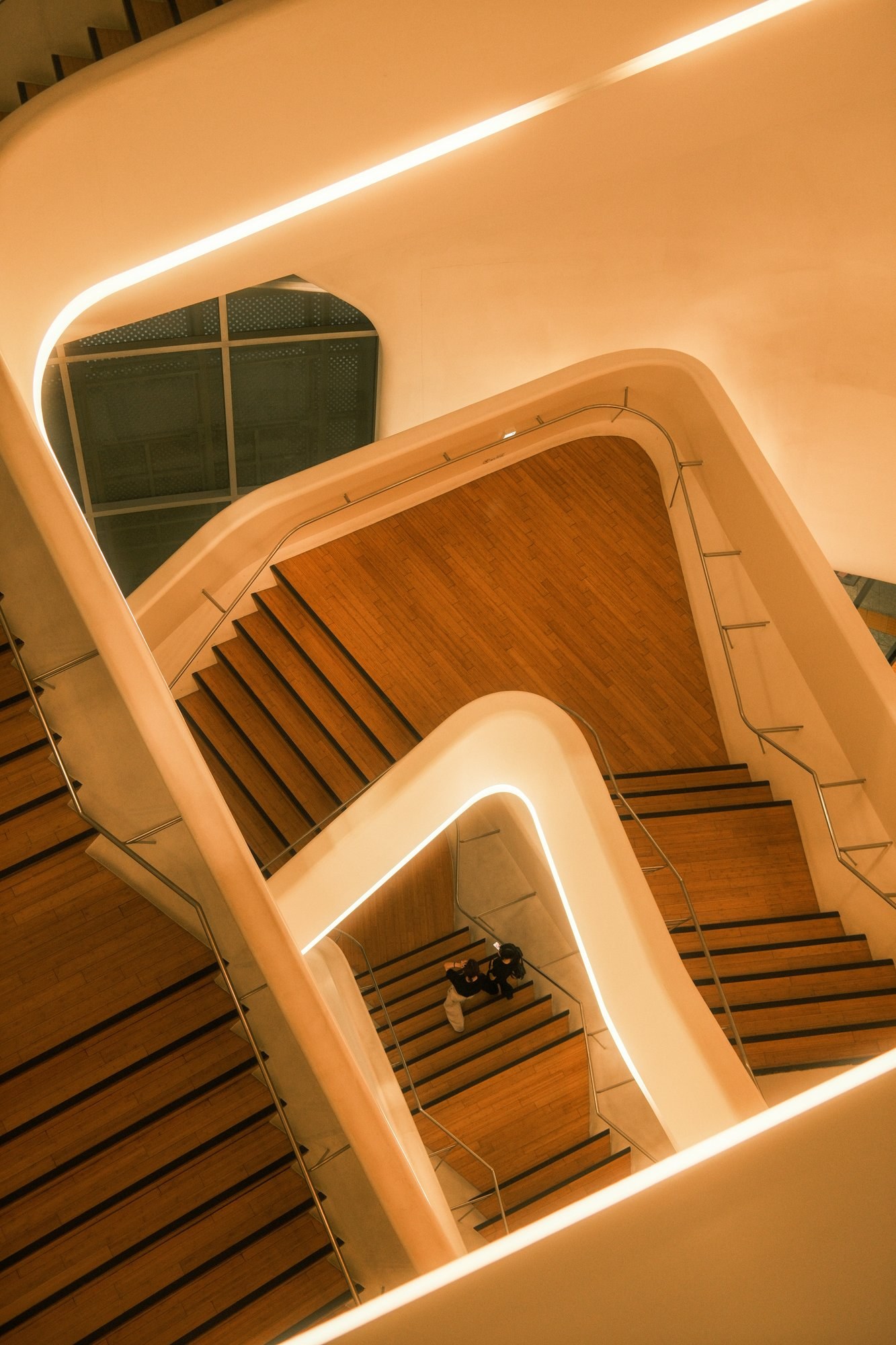 Looking down a curving wooden staircase
